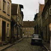 Een zijstraat met een trabbi in Rostock. Zo zagen veel straten in de DDR er uit.