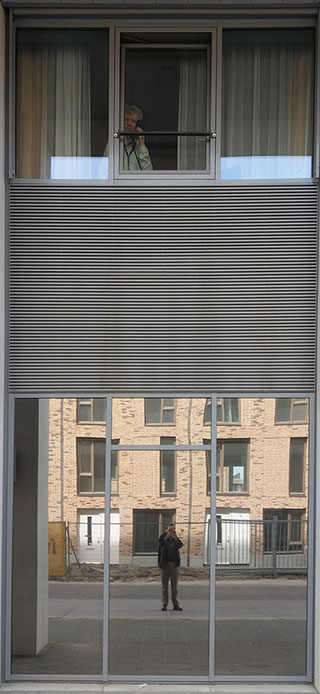 Mei 2020. Telefonerend met Hans voor zijn raam (zelf reflecterend in de onderste venster), want ik mag niet naar binnen.