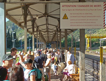 Drukte op het station van Villefranche-Vernet-Les-Bains, het beginpunt van de Petit Train Jaune. Wat er zo dodelijk gevaarlijk is (zie waarschuwingsbord, leg ik later in het verhaal uit).