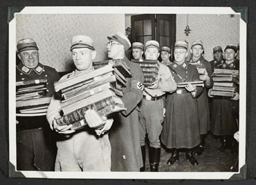 Frth, 10 november  SA-mannen dragen de buit van plunderingen uit een synagoge: de boeken worden gearchiveerd als er voor de nazis interessante documentatie in staat, f gaan op de brandstapel.