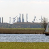 Een lelievlet met de Europoort op de achtergrond. Deze voormalig padvinder-boten waren berucht, omdat ze van staal zijn en je een aanvaring ermee dus beter kunt vermijden.