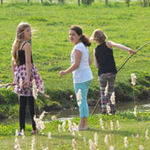 Kinderen aan het water: het wordt een traditie tijdens het wandelen. Deze geschminkte meisjes proberen iets uit het water te vissen.