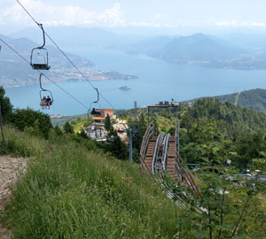 Voor de top moet je nog een stukje met een stoeltjeslift. Daar tref je ook een bobsleeparkoers. Het uitzicht op de Lago Maggiore is fenomenaal.